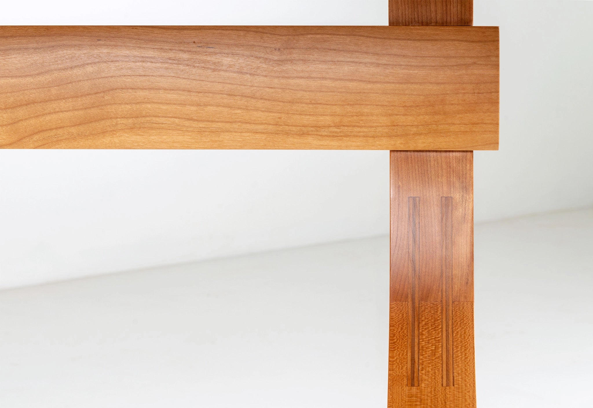 Close-up of a wooden table leg on a white background