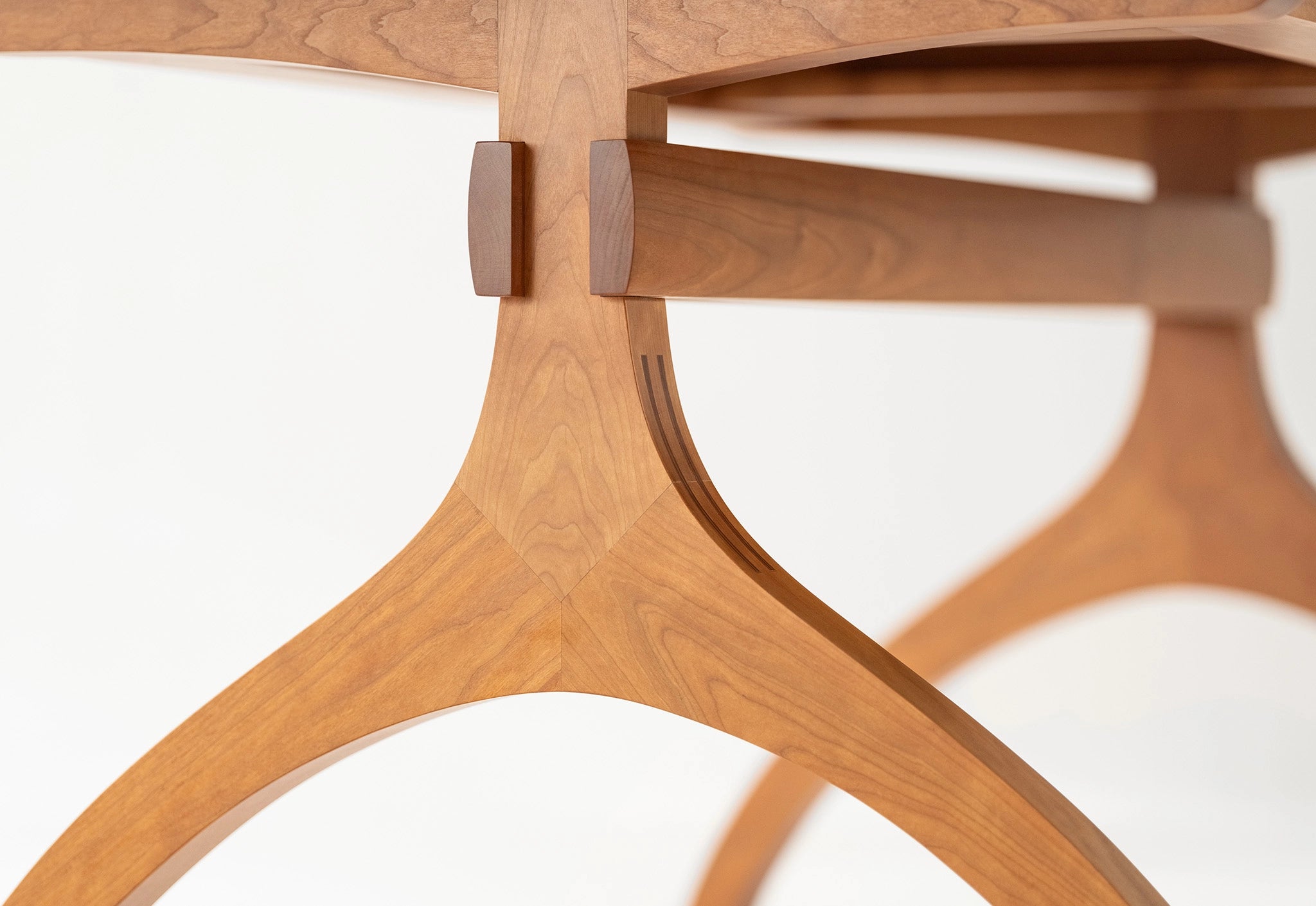 Close-up of a wooden chair with a white cushion on a light background
