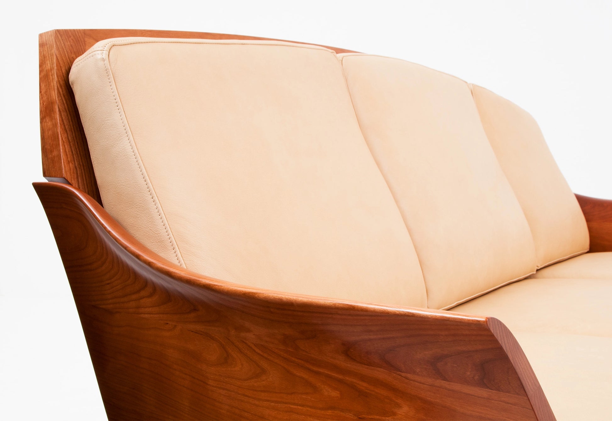 Beige sofa with wooden armrests on a white background