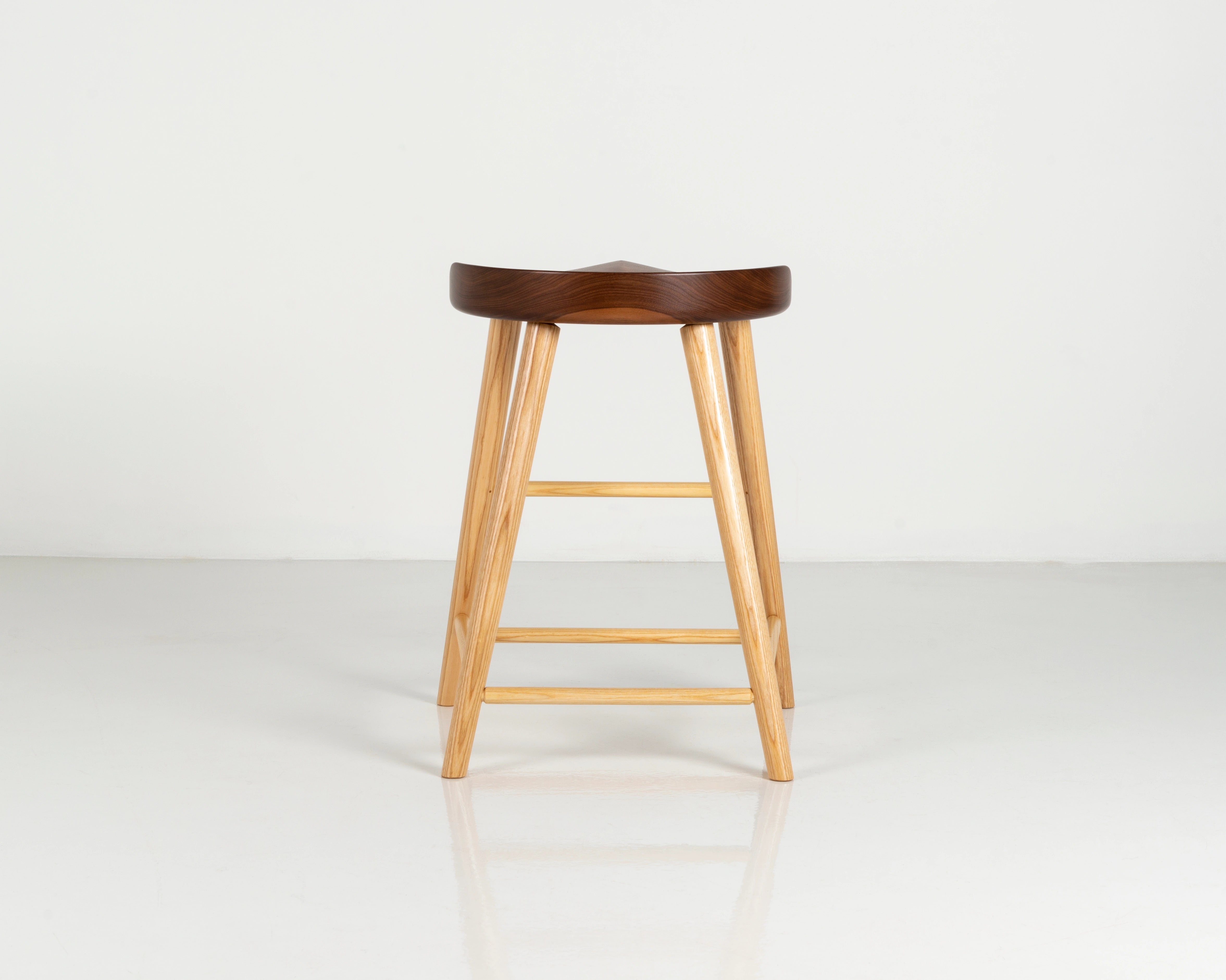 Wooden bar stool with a dark walnut seat on a white background