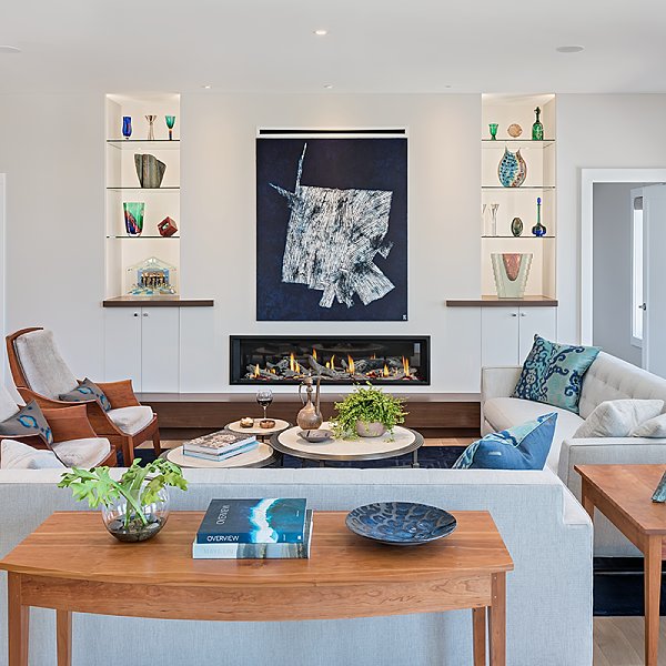 living room with cherry wood lounge chairs, cherry side tables, glass fireplace, recessed shelving