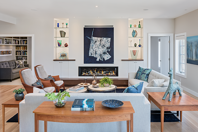 living room with cherry wood lounge chairs, cherry side tables, glass fireplace, recessed shelving
