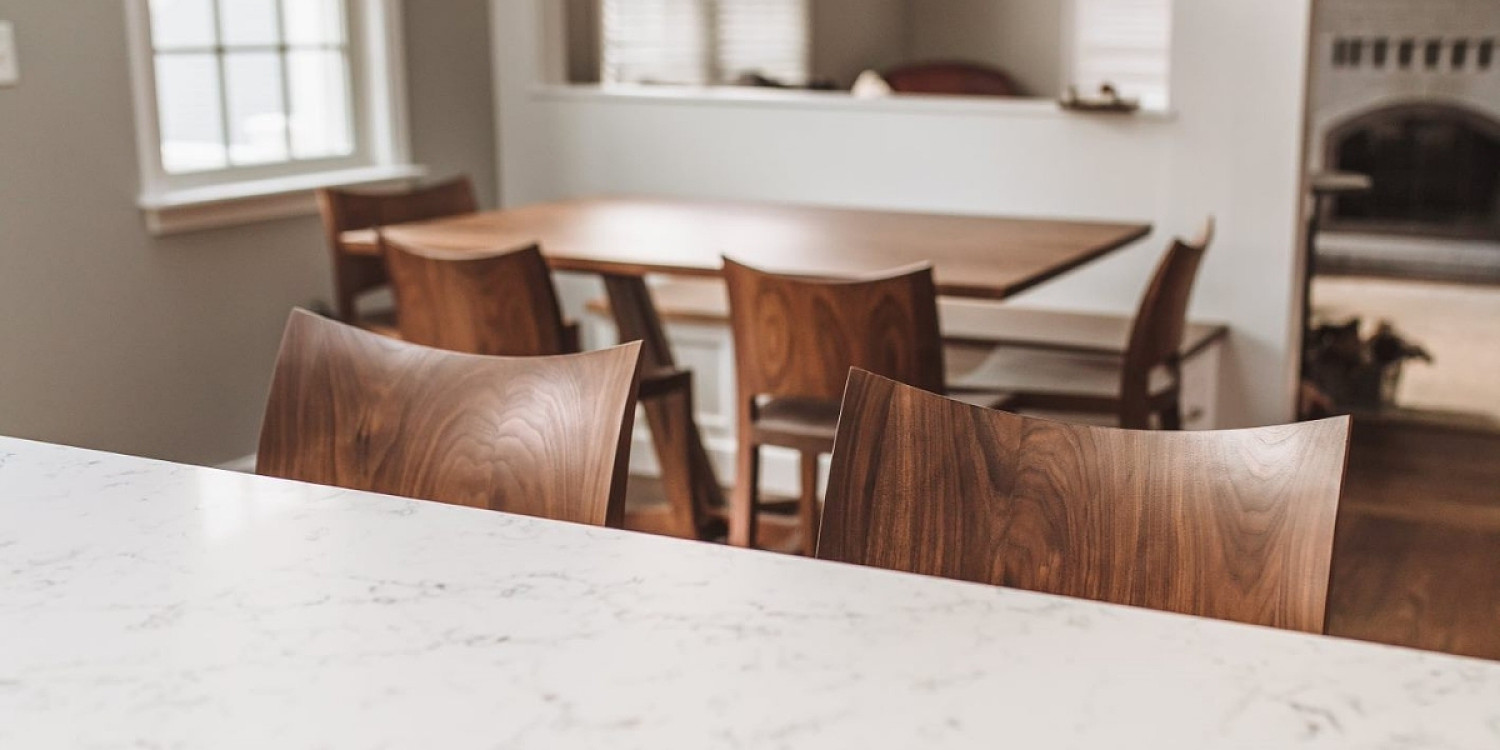 Top detail of Auburn Stools at marble kitchen island with auburn chairs and Edo trestle table in the background