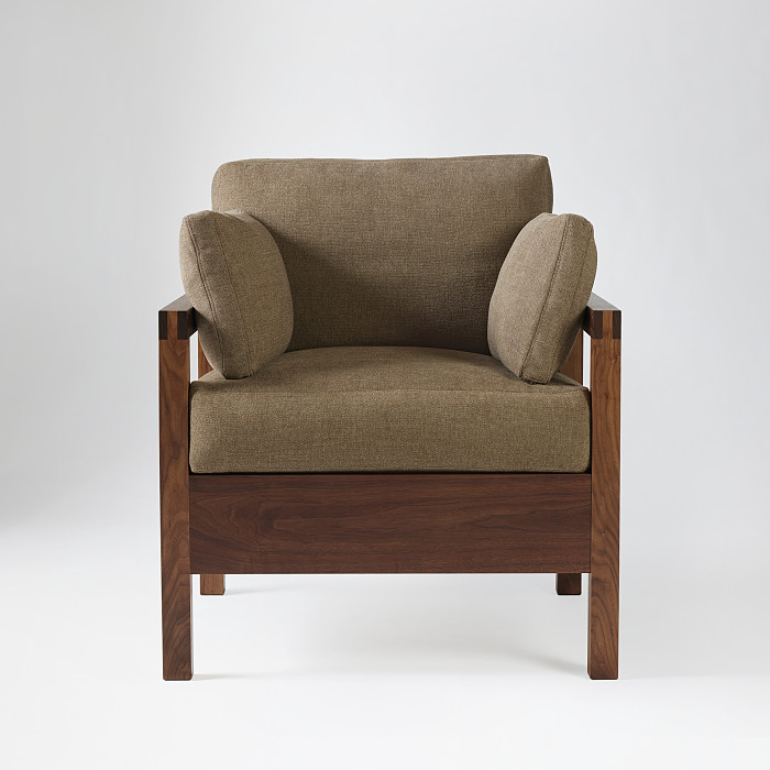 Front view of studio lounge chair in walnut with brown fabric upholstery