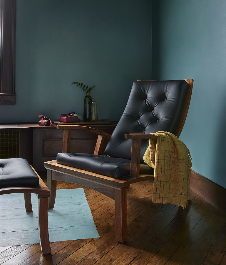 Lolling Chair in cherry and black leather with yellow throw blanket