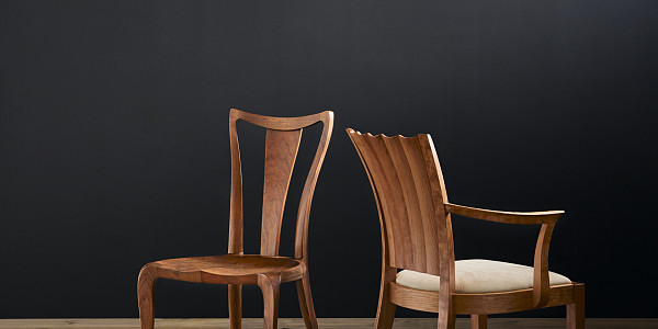 Pasadena Chair in walnut on left and Aria Arm Chair in Cherry with cream upholstered seat cushion on right