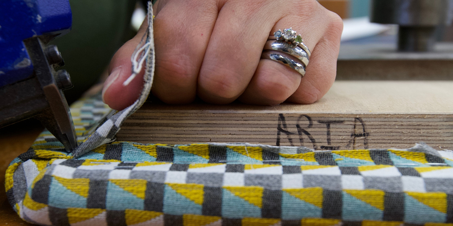 Hand pulling on upholstery for seat cushion