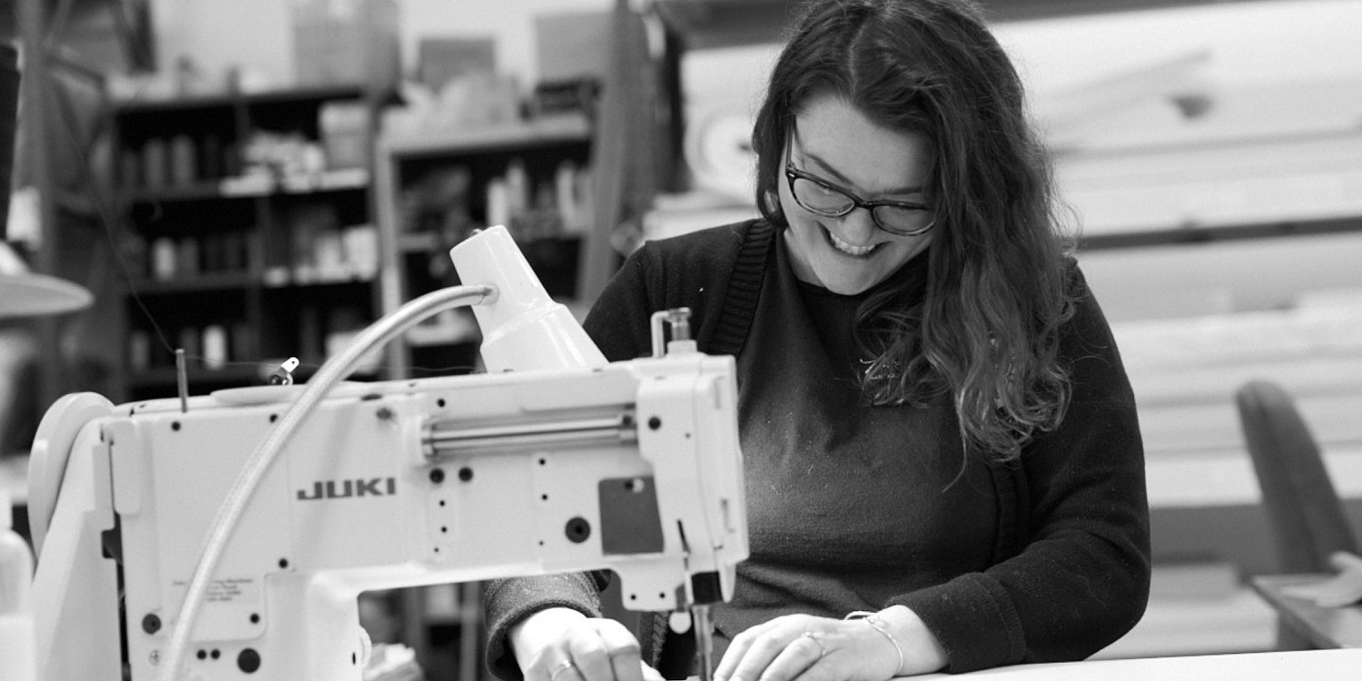 woman smiling working at a sewing machine