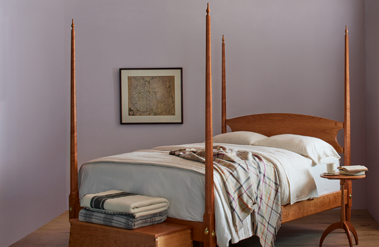 pencil post bed with picture on wall and side table to right