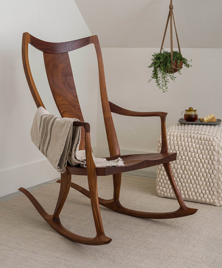 Wooden rocking chair placed in the corner of a room.