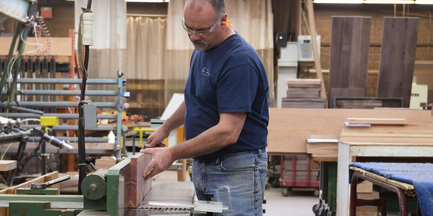 man cutting cedar on a joiner