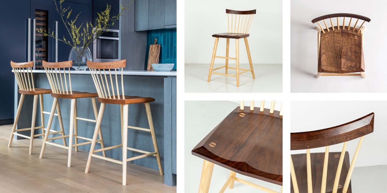 Wooden stools at a kitchen island. There is vase with flowering twigs on the counter. the kitchen has blue tile backsplash and grey colored cabinets